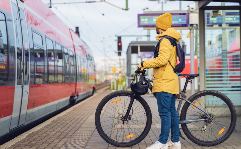 Ein Mann steht am Bahnhof und will mit seinem Fahrrad in den Zug einsteigen. Ein Mann steht am Bahnhof und will mit seinem Fahrrad in den Zug einsteigen.